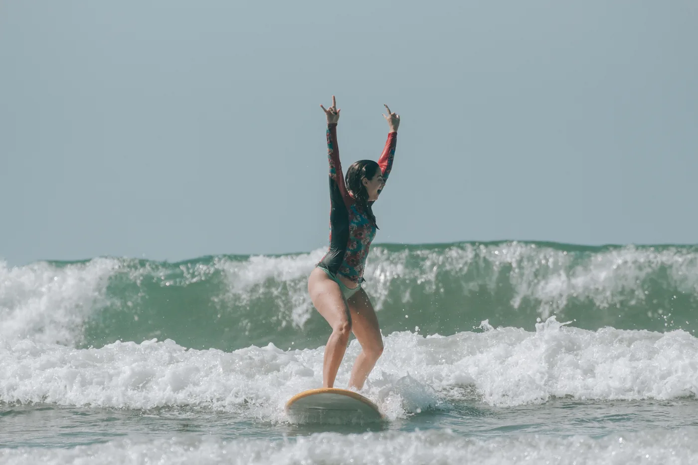 Mulher aprendendo a surfar diante do oceano